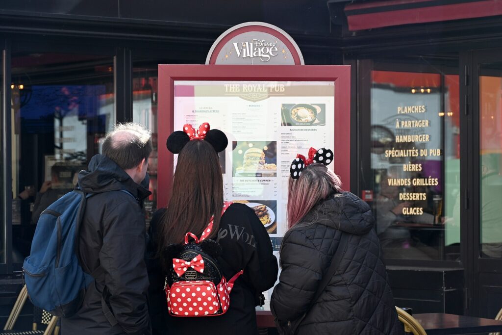 Guests choosing a restaurant menu at Disney Village beside Disneyland Paris