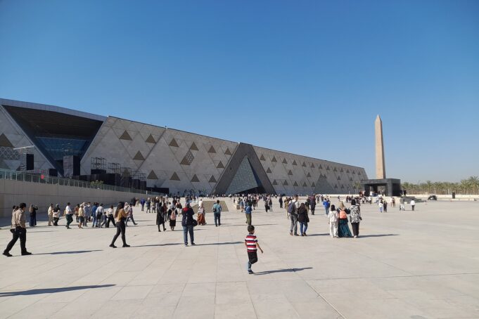 Grand Egyptian Museum modern exterior with visitors in Giza, Egypt