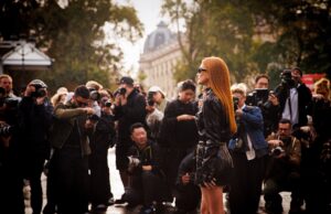 Women’s Paris Fashion Week 2026: The Dates, Shows & Secrets Worth Knowing Elegant guest arriving amid photographers at Women's Paris Fashion Week