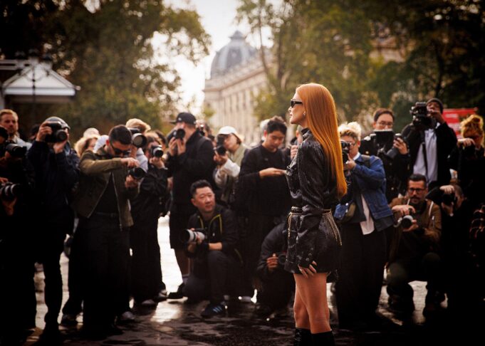 Elegant guest arriving amid photographers at Women's Paris Fashion Week