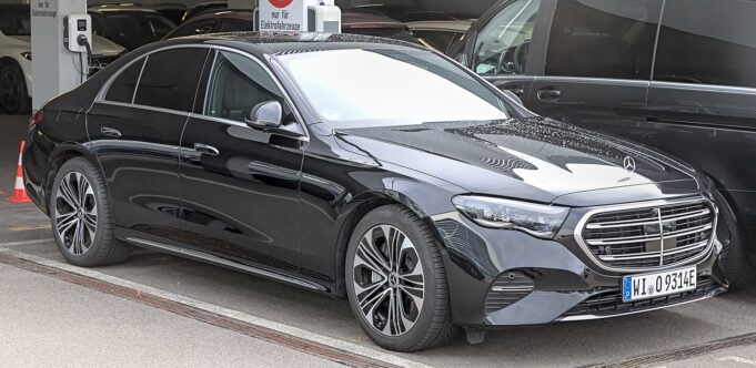 Modern black Mercedes E-Class with other premium vehicles in a Paris chauffeur fleet
