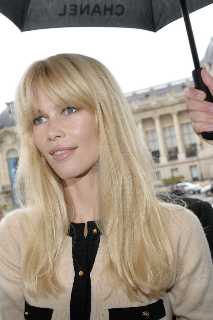 Claudia Schiffer arriving beneath a Chanel umbrella during Paris Fashion Week