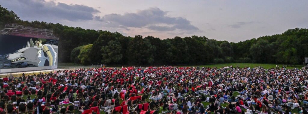 Grand écran de cinéma en plein air et public sur la pelouse du parc de La Villette à Paris