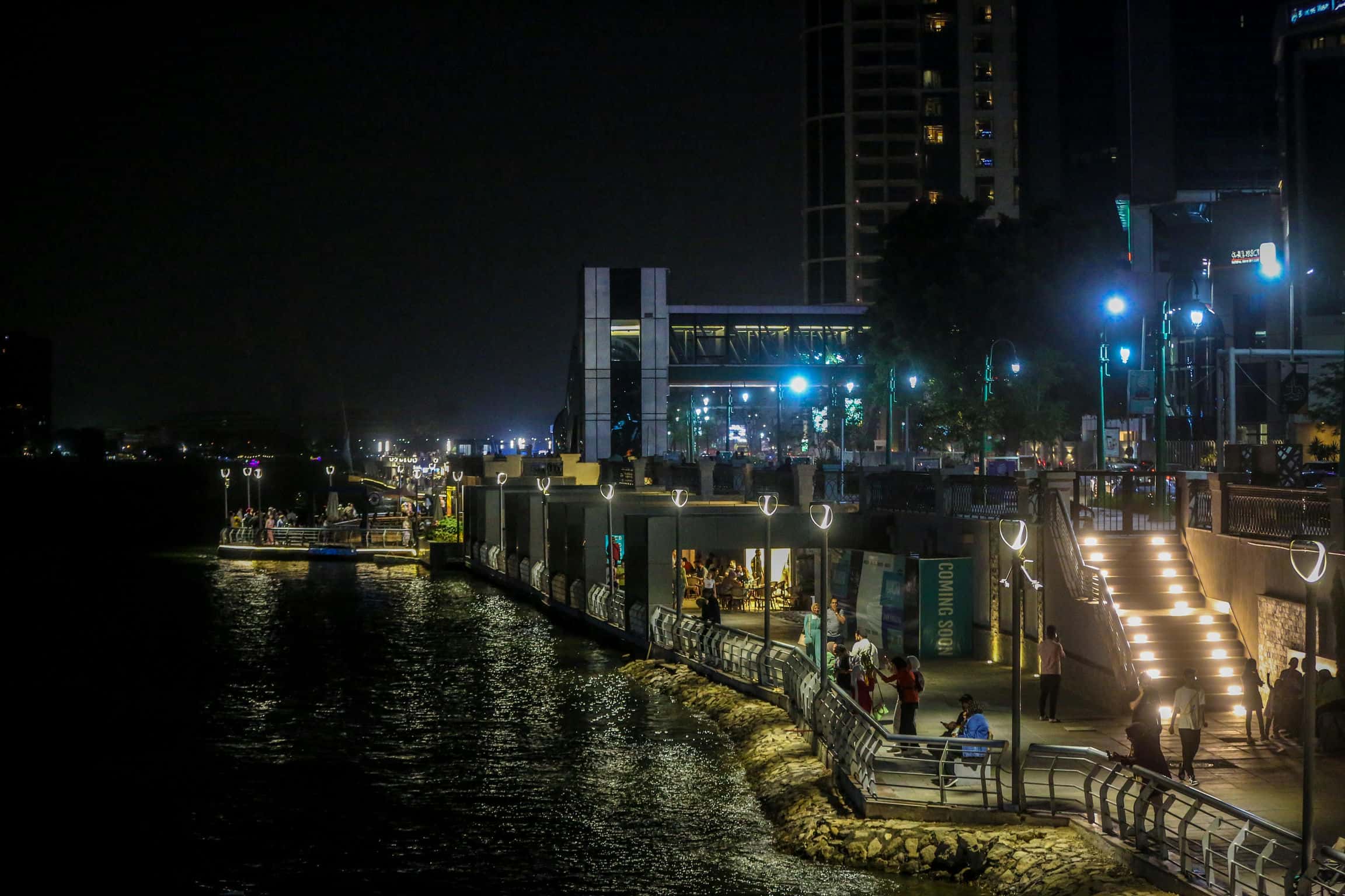 Modern Cairo Nile Corniche at night with visitors and hospitality venues