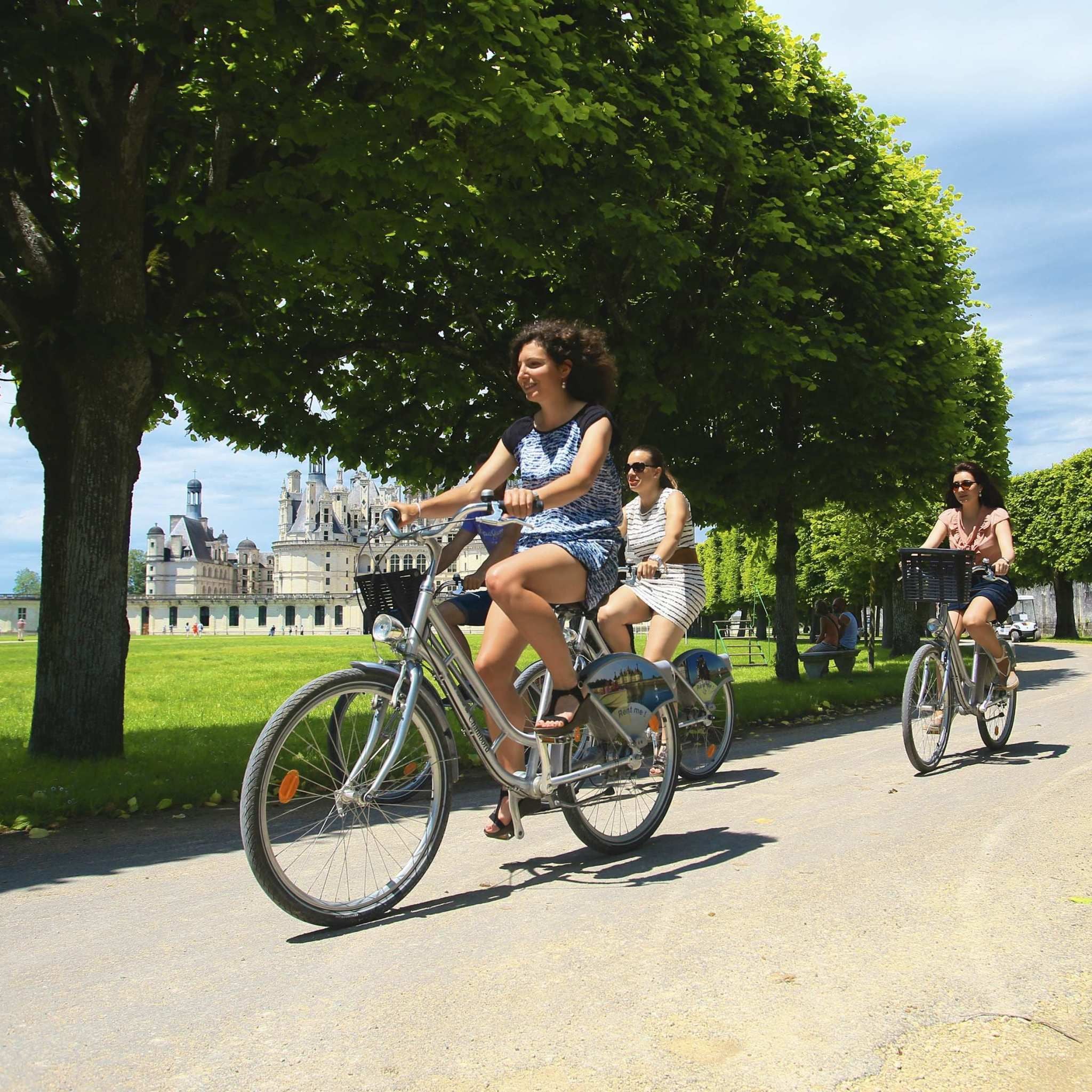 Cyclists at Château de Chambord illustrating higher-value regional itineraries in France
