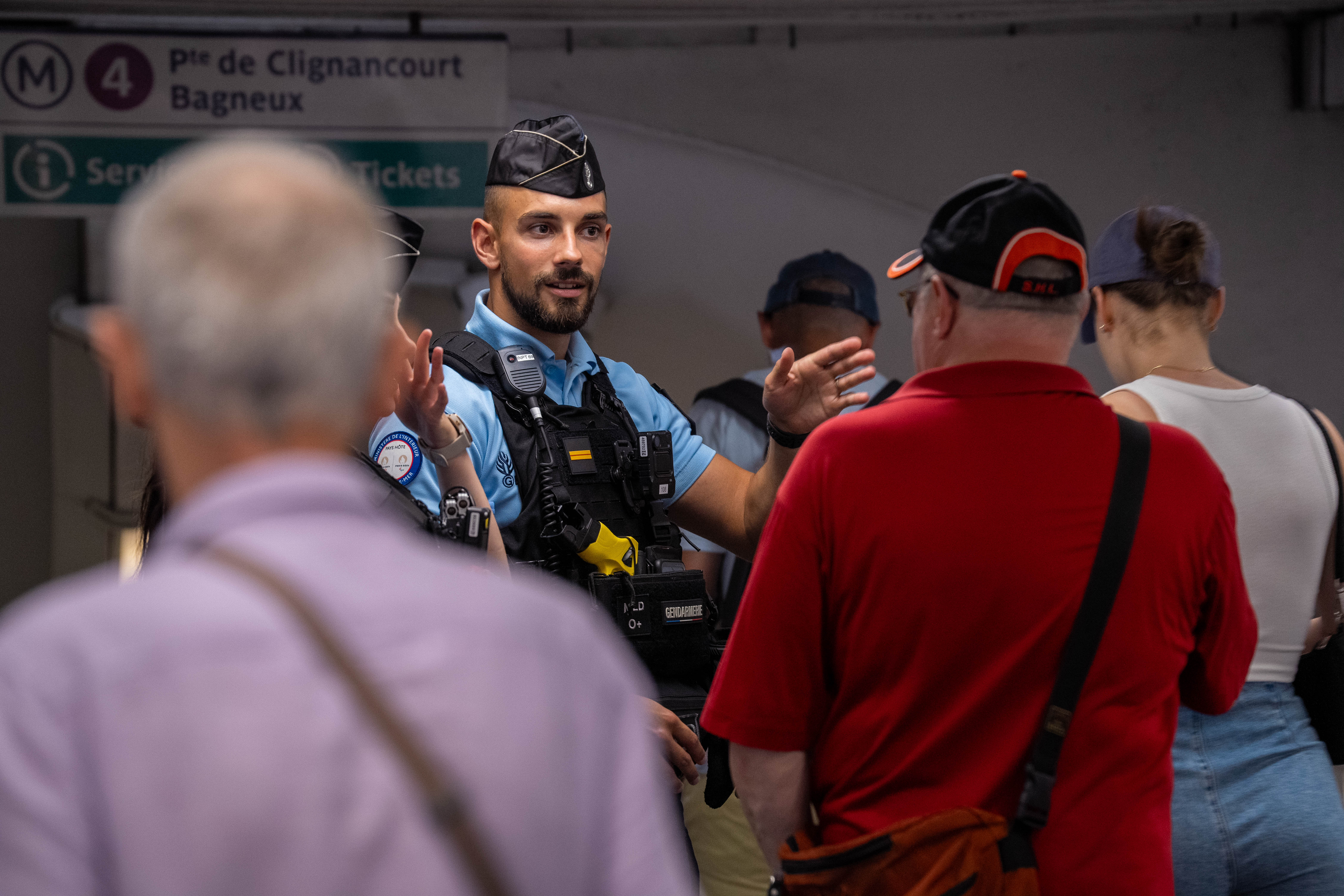 French gendarme assisting international tourists in the Paris Metro