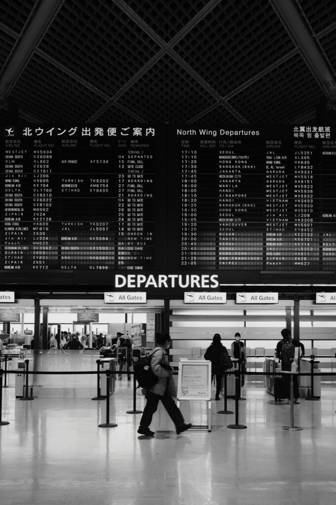 Global Travelers Beneath an Airport Departure Board International travelers beneath an airport departure board illustrating the reach of global tourism companies