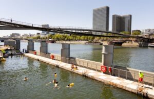 10 activités gratuites à Paris cet été 2026 : baignade dans la Seine, cinéma en plein air et expériences secrètes Swimmers at the Bercy Seine bathing site with the Bibliothèque nationale de France in view