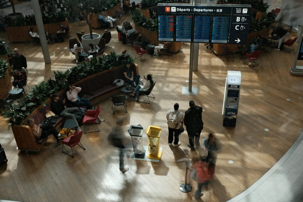 Travelers waiting in a modern airport terminal shaped by global tourism platforms