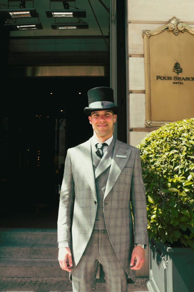 Professional hotel concierge in formal attire demonstrating luxury hospitality standards