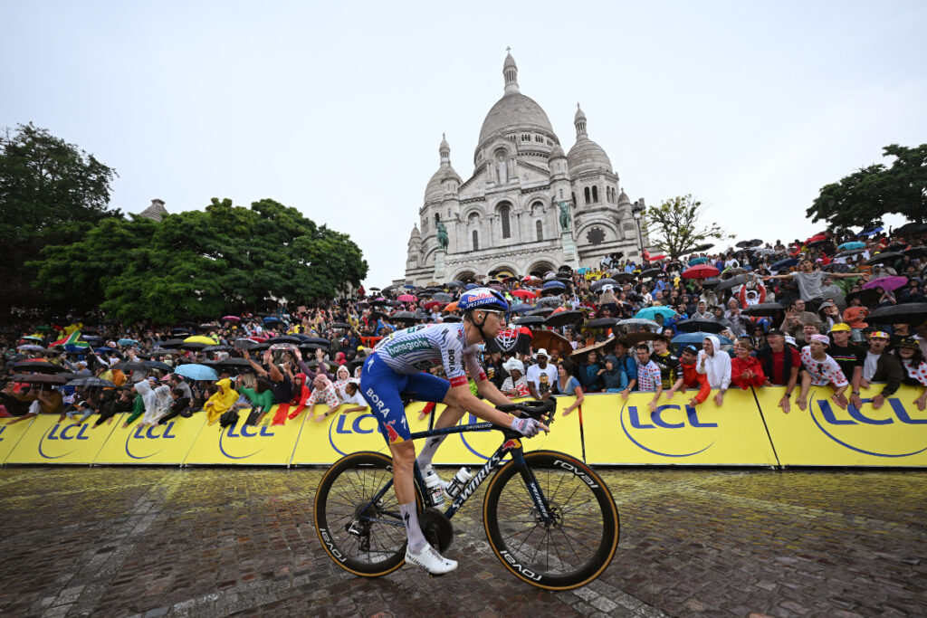 Coureur du Tour de France gravissant Montmartre près du Sacré-Cœur lors du final parisien 2025