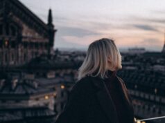 Best Rooftop Bars in Paris — Where to Drink with a View Traveller overlooking the Eiffel Tower from a Paris rooftop at dusk
