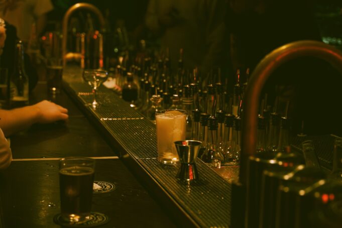 Bartender preparing cocktails in a dark intimate speakeasy-style bar
