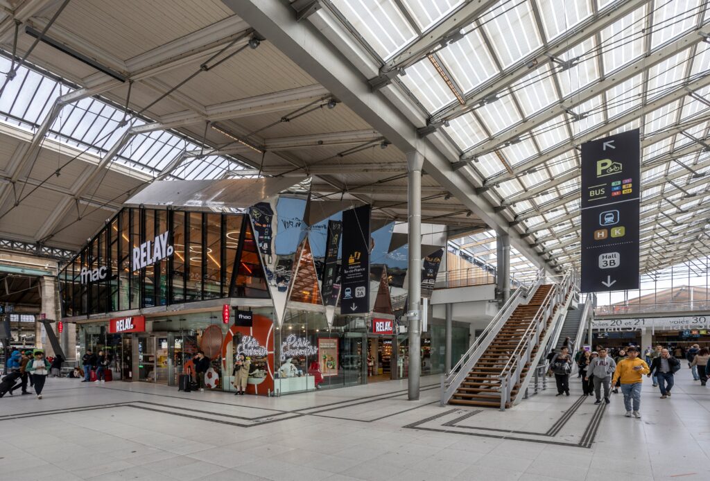 Passengers moving through the modern Hall 3B concourse at Paris Gare du Nord