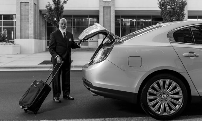 Professional chauffeur loading luggage for a business transfer Professional chauffeur loading luggage into a premium sedan for a business transfer in France