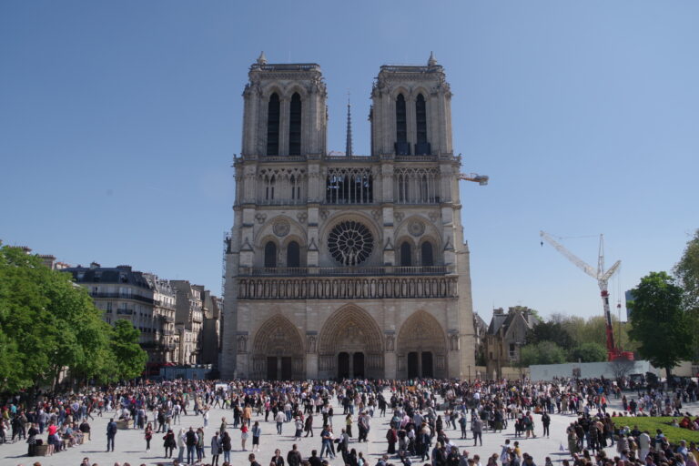 Restored Notre-Dame de Paris with visitors on the parvis after reopening