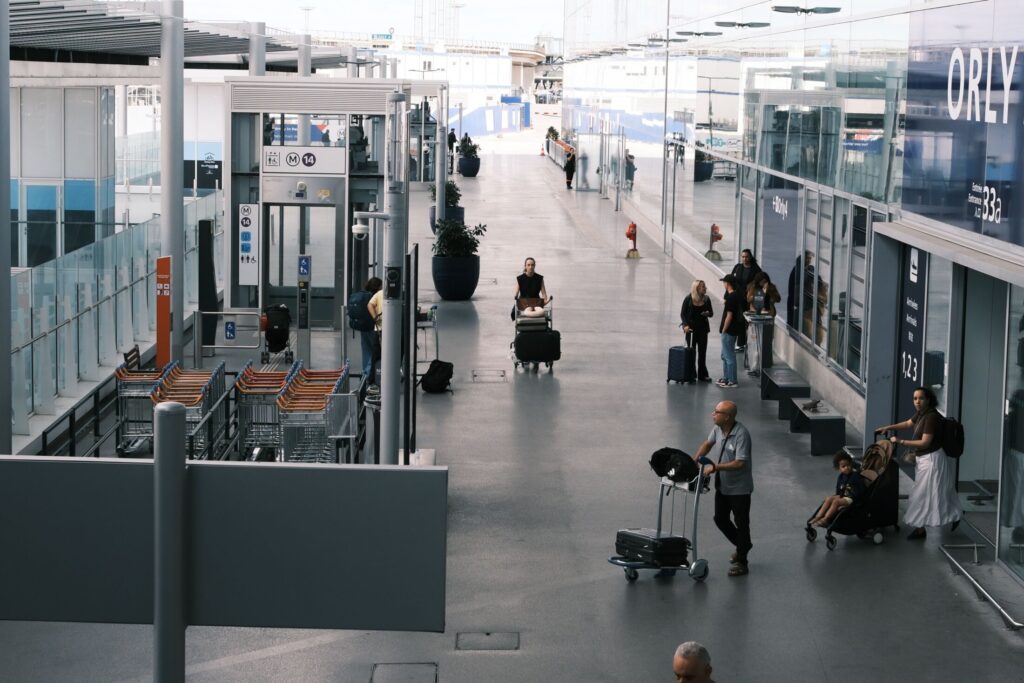 International travellers with luggage moving through a modern Paris airport terminal