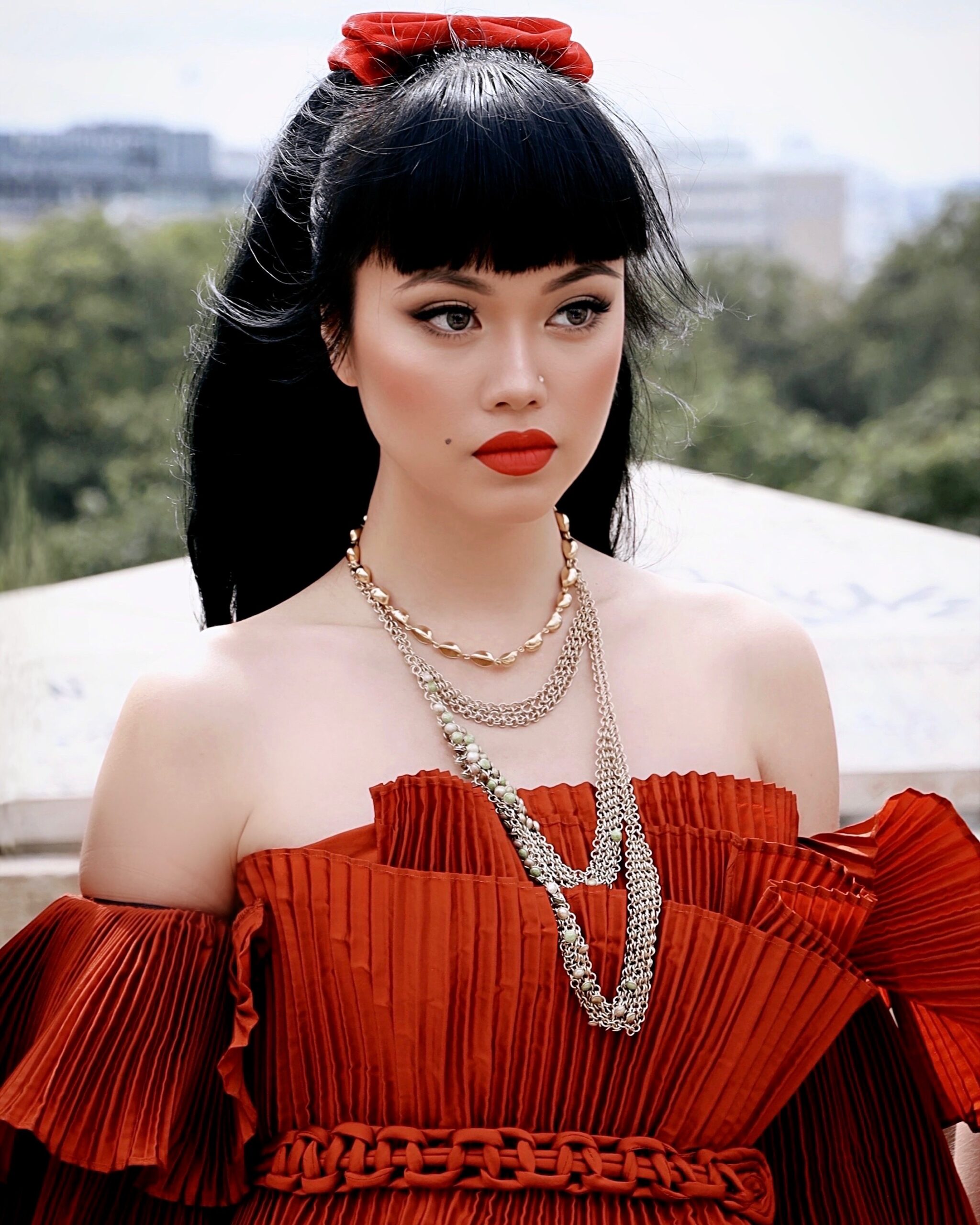 Invitée en robe couture rouge pendant la Fashion Week de Paris 2025