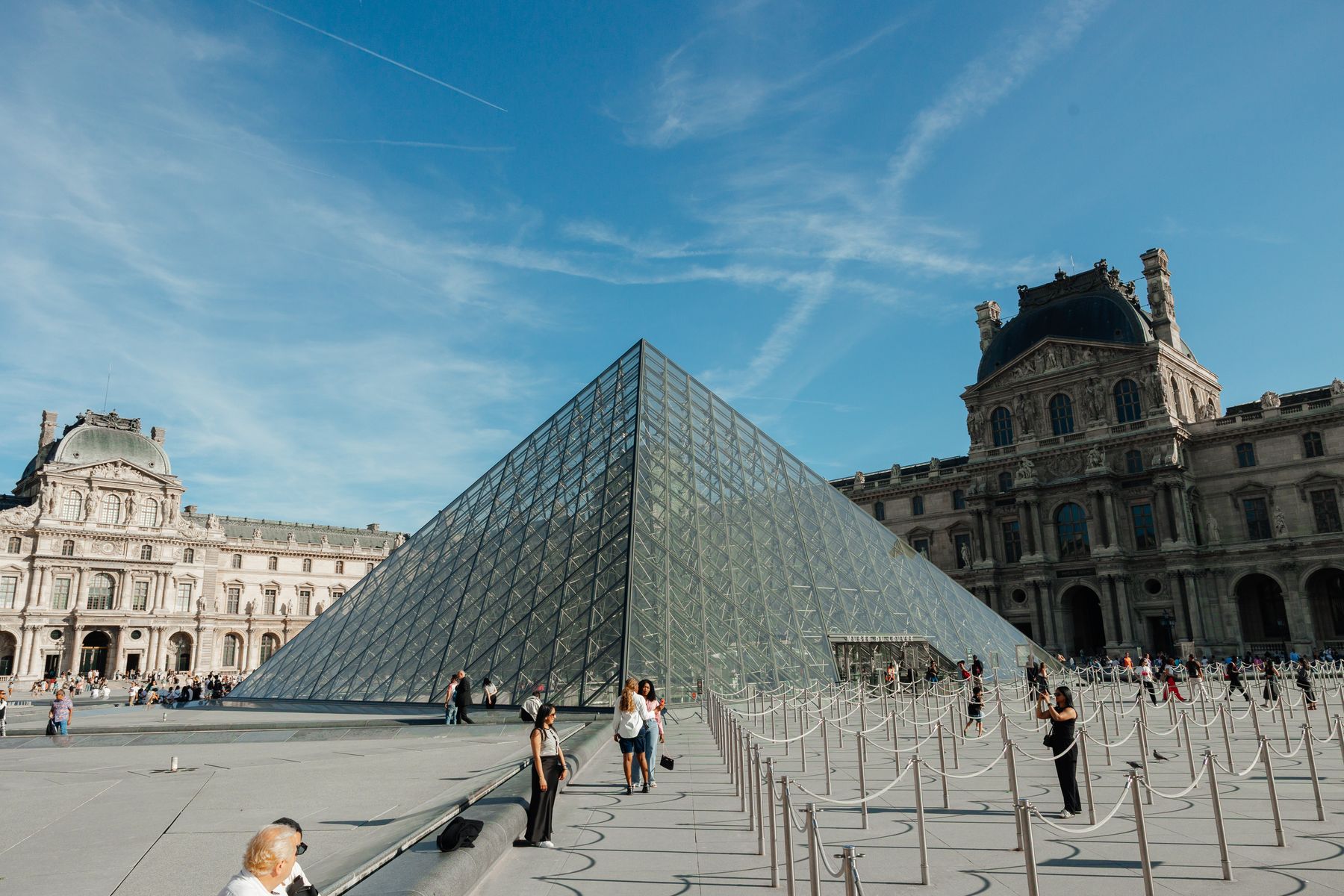 Visiteurs autour de la pyramide du Louvre pendant un itinéraire matinal à Paris