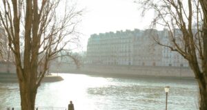 Where to Go in Paris in the Morning? A Perfect Half-Day Itinerary for Every Traveller Traveller walking beside the Seine in calm morning light during a Paris itinerary