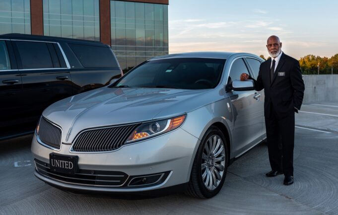 Professional chauffeur beside a premium car for Paris travel-agency clients