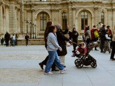 L’été du Golfe à Paris : pourquoi ces visiteurs comptent — et ce que 2026 met à l’épreuve Familles se promenant devant le musée du Louvre à Paris pendant l’été