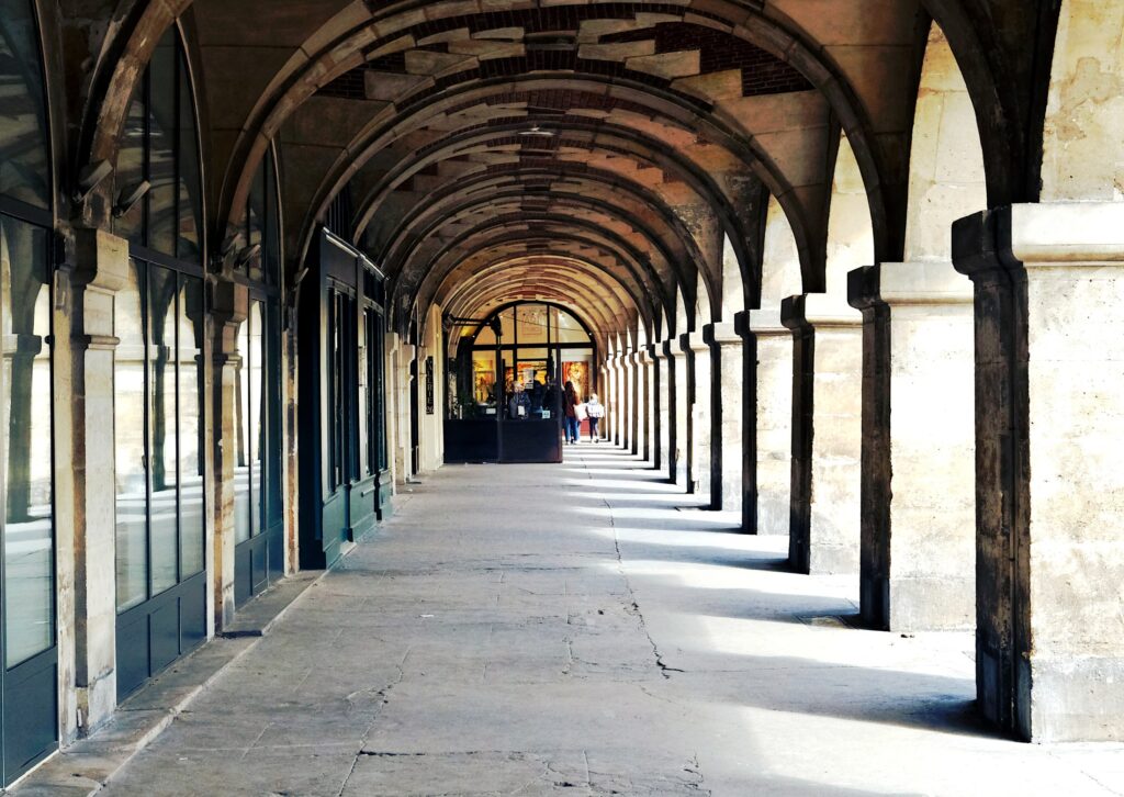 Long covered stone arcades at Place des Vosges in Paris's Marais district
