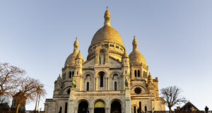 باريس في ثلاثة أيام: البرنامج السياحي المثالي للزيارة الأولى (دليل 2026) Upward view of the white Sacré-Cœur Basilica façade in Montmartre, Paris