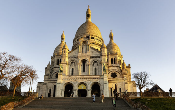 Sacré-Cœur above Montmartre Upward view of the white Sacré-Cœur Basilica façade in Montmartre, Paris