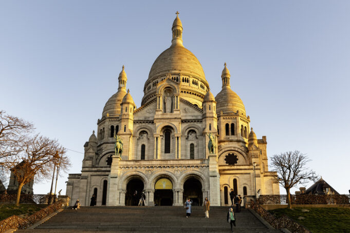 Sacré-Cœur above Montmartre Upward view of the white Sacré-Cœur Basilica façade in Montmartre, Paris
