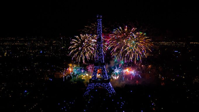 Paris, capitale événementielle sous les feux Panorama nocturne de Paris et feu d’artifice autour de la tour Eiffel vu de Montparnasse