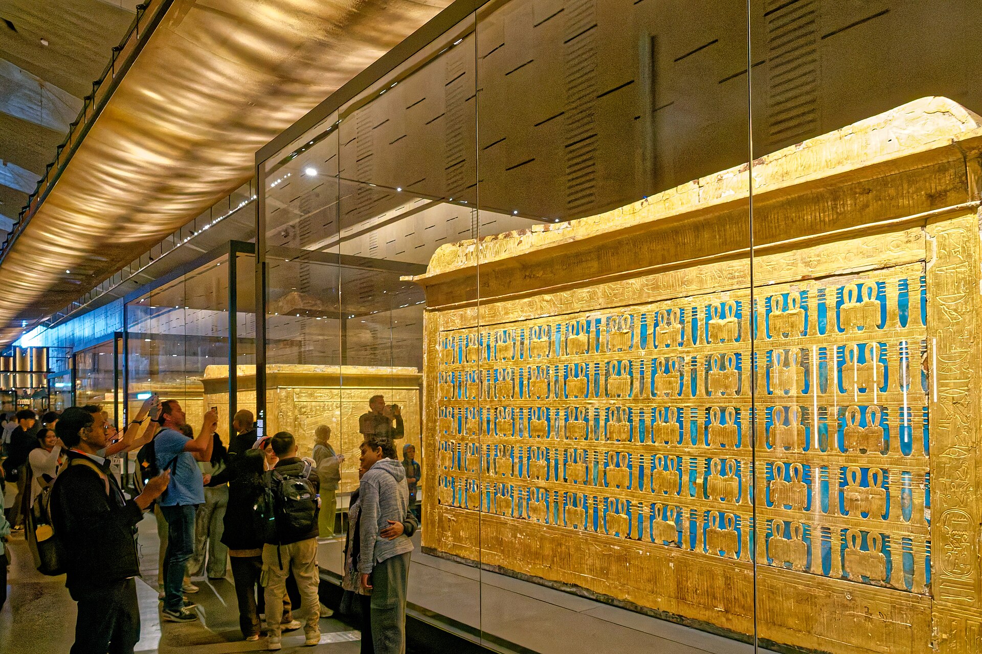 Visitors viewing gilded objects from the Tutankhamun collection at the Grand Egyptian Museum