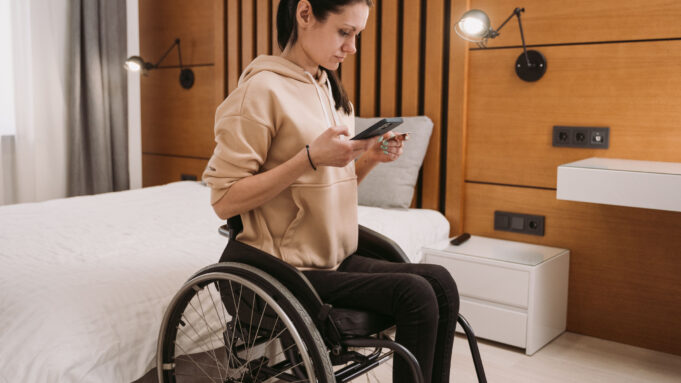 Wheelchair user in a modern hotel-style bedroom