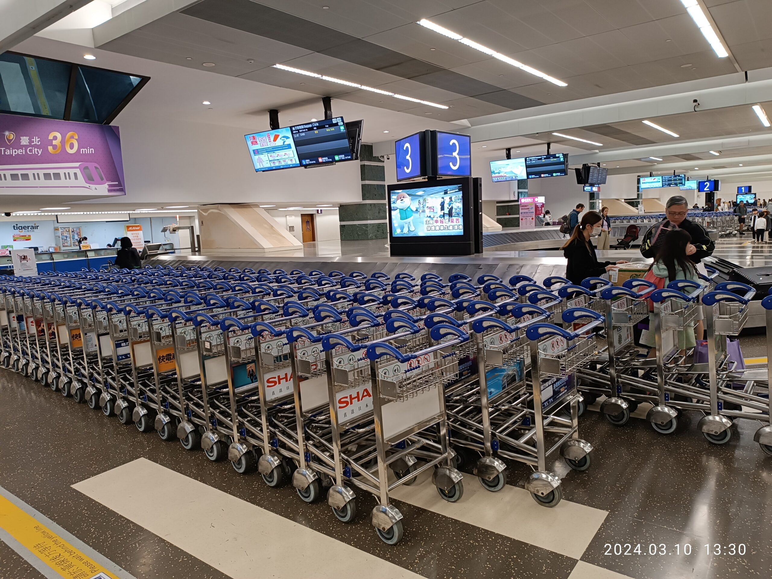 Passengers collect luggage from baggage carousels at Taiwan Taoyuan International Airport in March 2024.