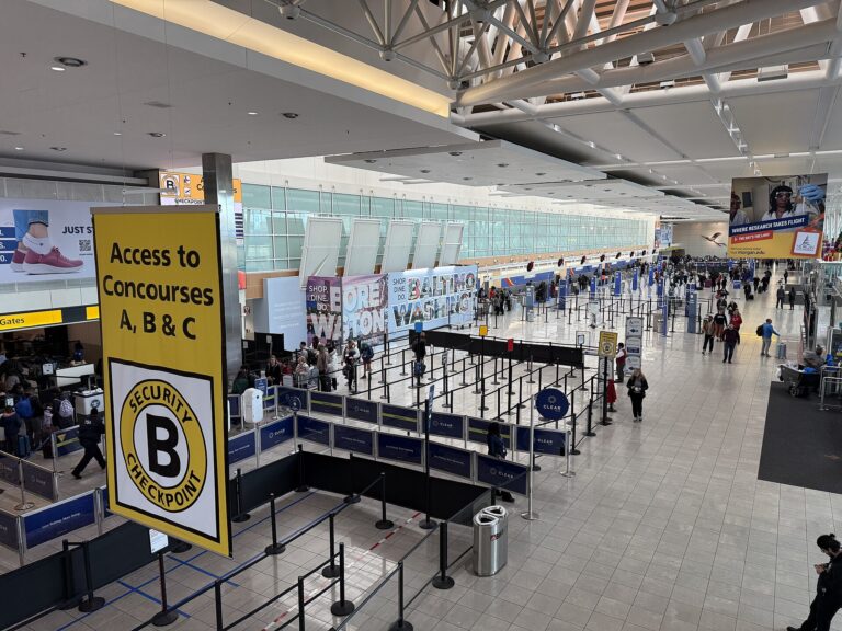 Real photograph of an organized airport security checkpoint and passenger queues