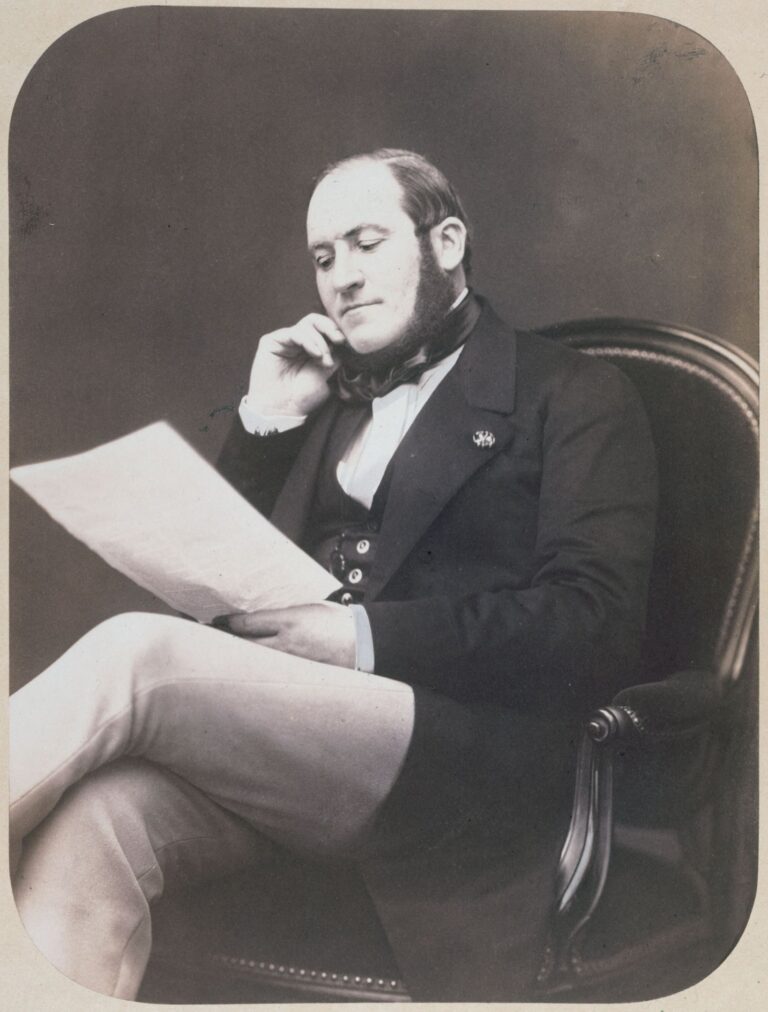 Le baron Georges-Eugène Haussmann assis, un document à la main, photographié par Pierre Petit en 1864
