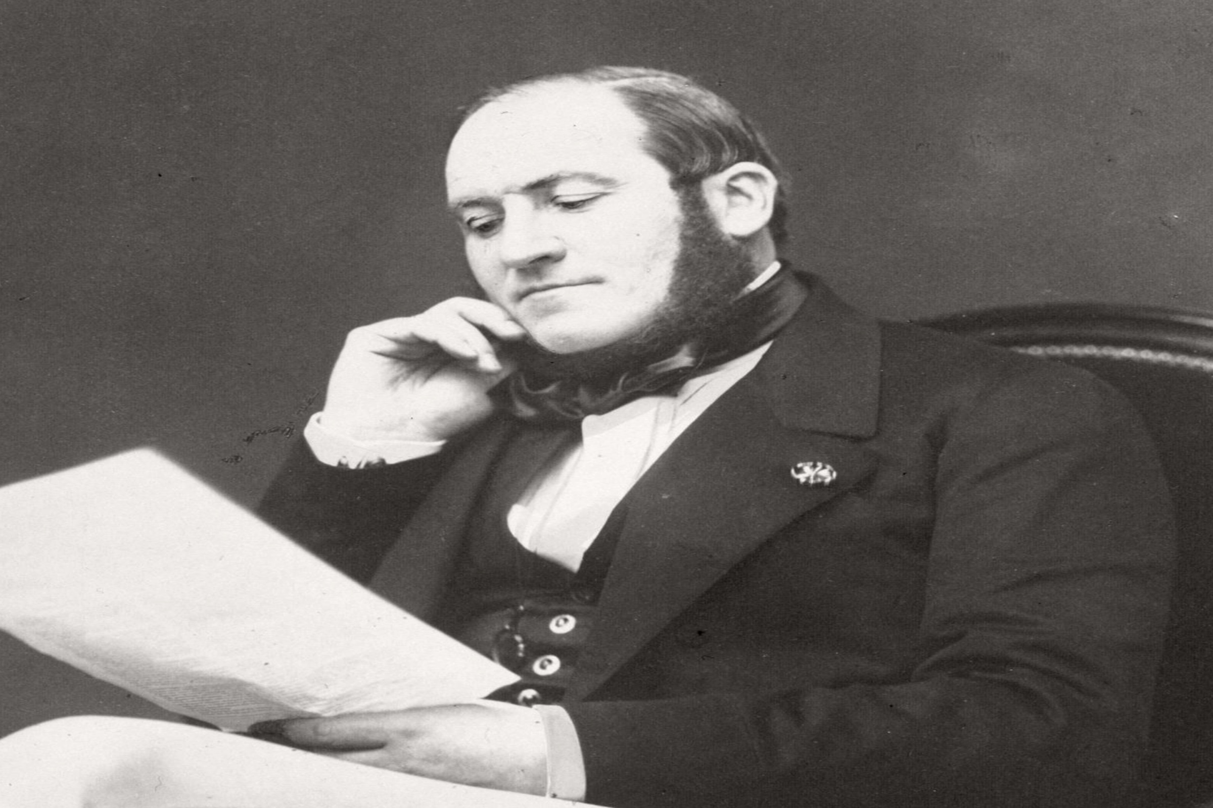 Baron Georges-Eugène Haussmann seated with a document in an 1864 portrait by Pierre Petit