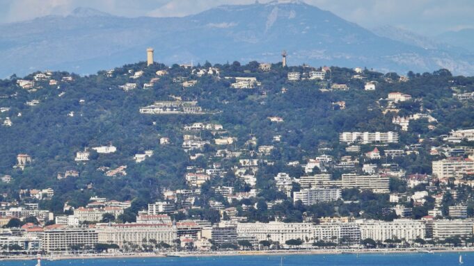 Cannes real estate: La Croisette, the palaces and the residential hills Panoramic view of La Croisette hotels and Cannes hillside residences from the Mediterranean