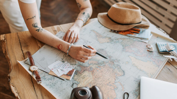 Planning a personalised journey through France Traveller planning a France journey with maps, documents and camera