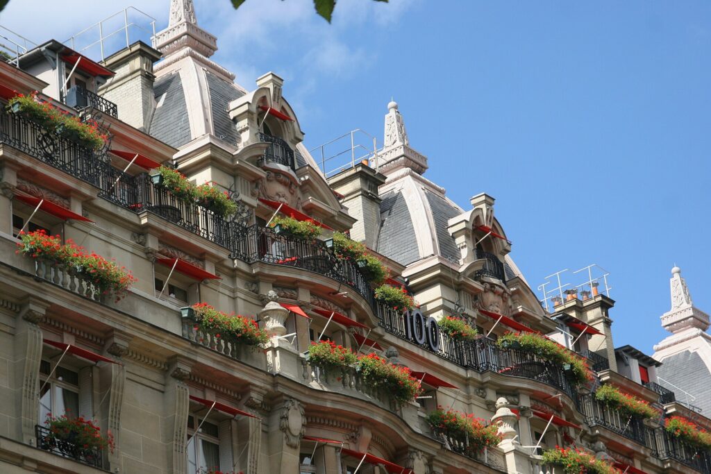 Red awnings flowers and wrought-iron balconies at Hôtel Plaza Athénée