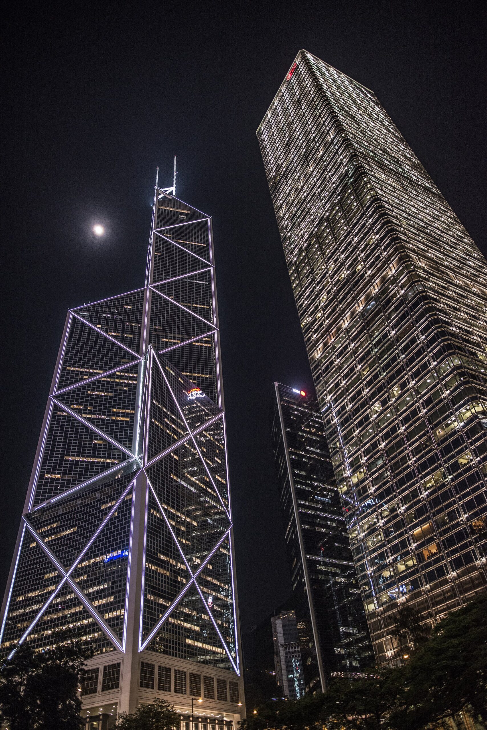 Bank of China Tower and Cheung Kong Center illuminated at night in Hong Kong, with I. M. Pei’s triangular tower at left