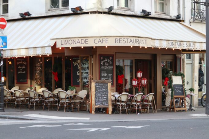 Identité parisienne : café historique et rue haussmannienne Café parisien historique au pied d’une architecture haussmannienne