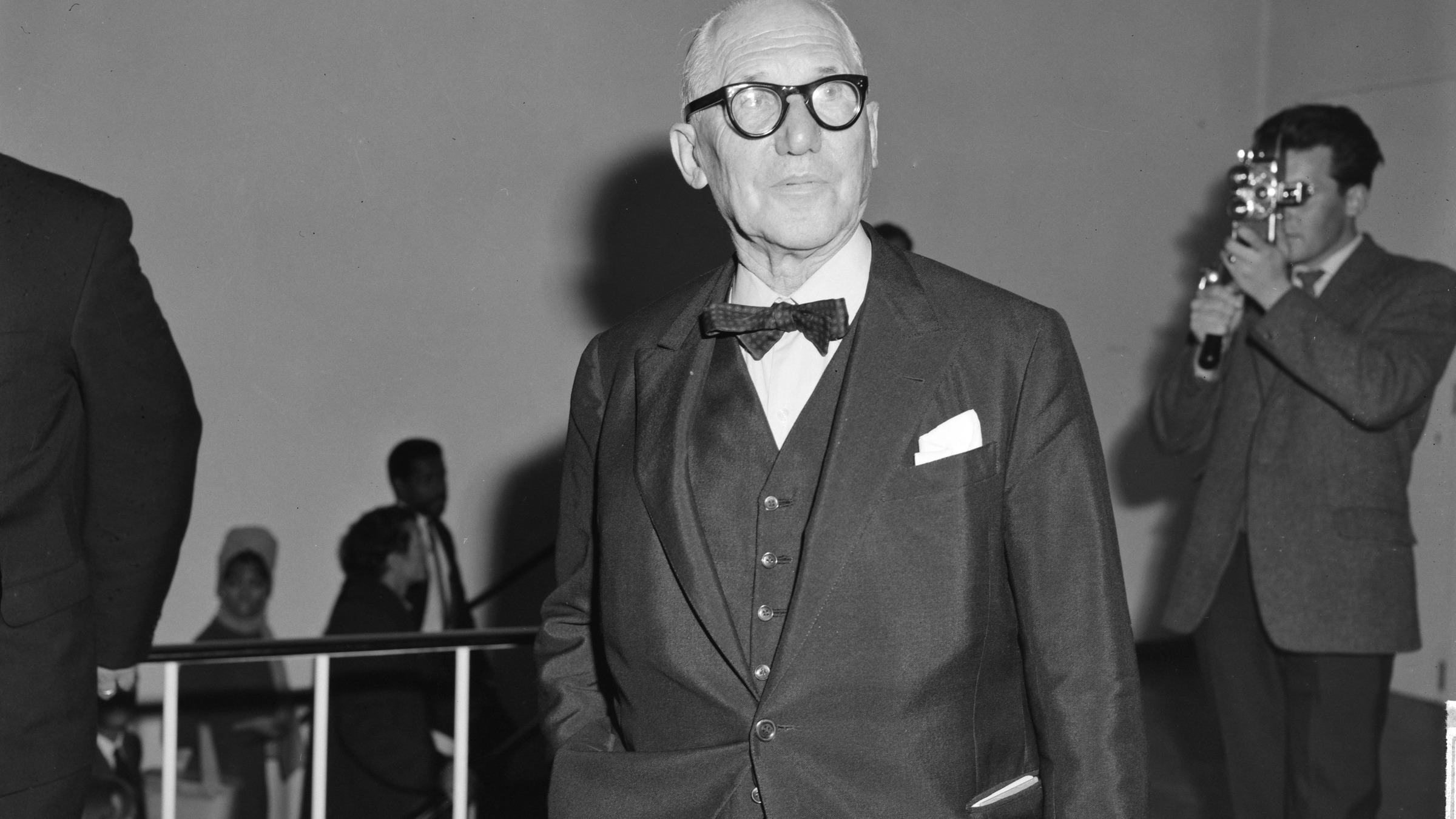 Le Corbusier in a dark suit and bow tie at the Stedelijk Museum in Amsterdam in 1964
