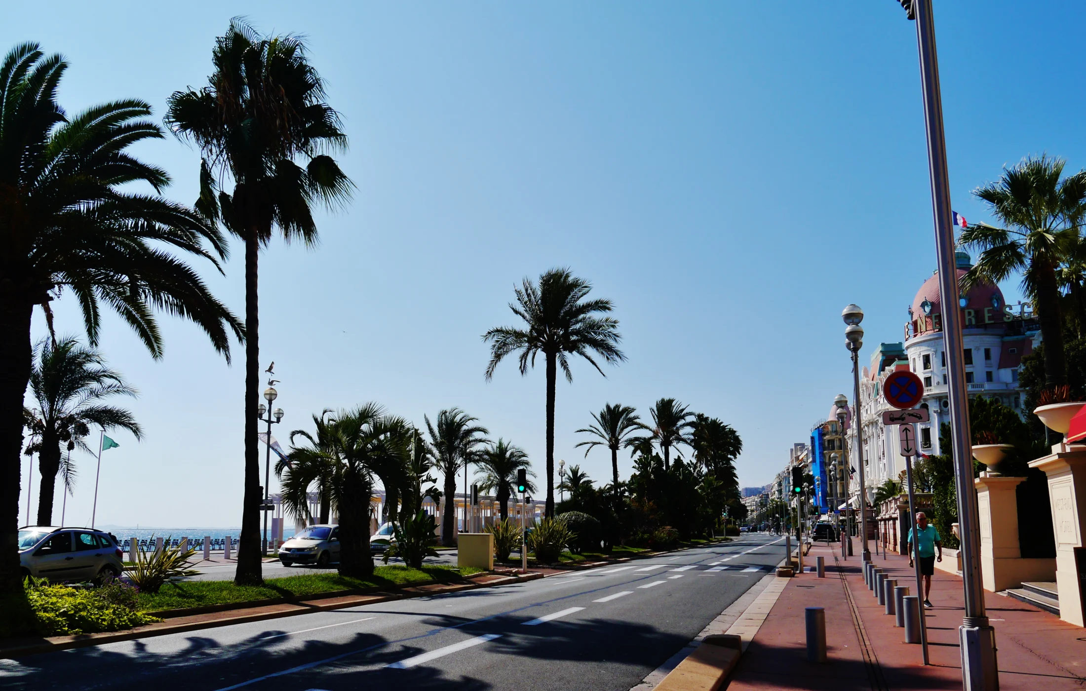Promenade des Anglais in Nice with roadway, palm trees and the Mediterranean