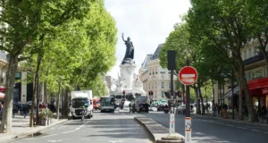 Ville de liberté : où s’arrête la liberté individuelle et où commencent les droits de la ville ? Boulevard parisien animé menant au Monument à la République, entre piétons, cyclistes et circulation