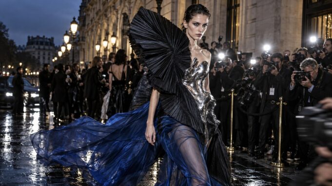 Paris Fashion Week 2026 avant-garde flash editorial — English edition Avant-garde model in sculptural silver, black and cobalt fashion outside a Paris show