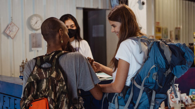 Group travellers checking in at a Paris hotel Friends with luggage checking in together at a hotel reception