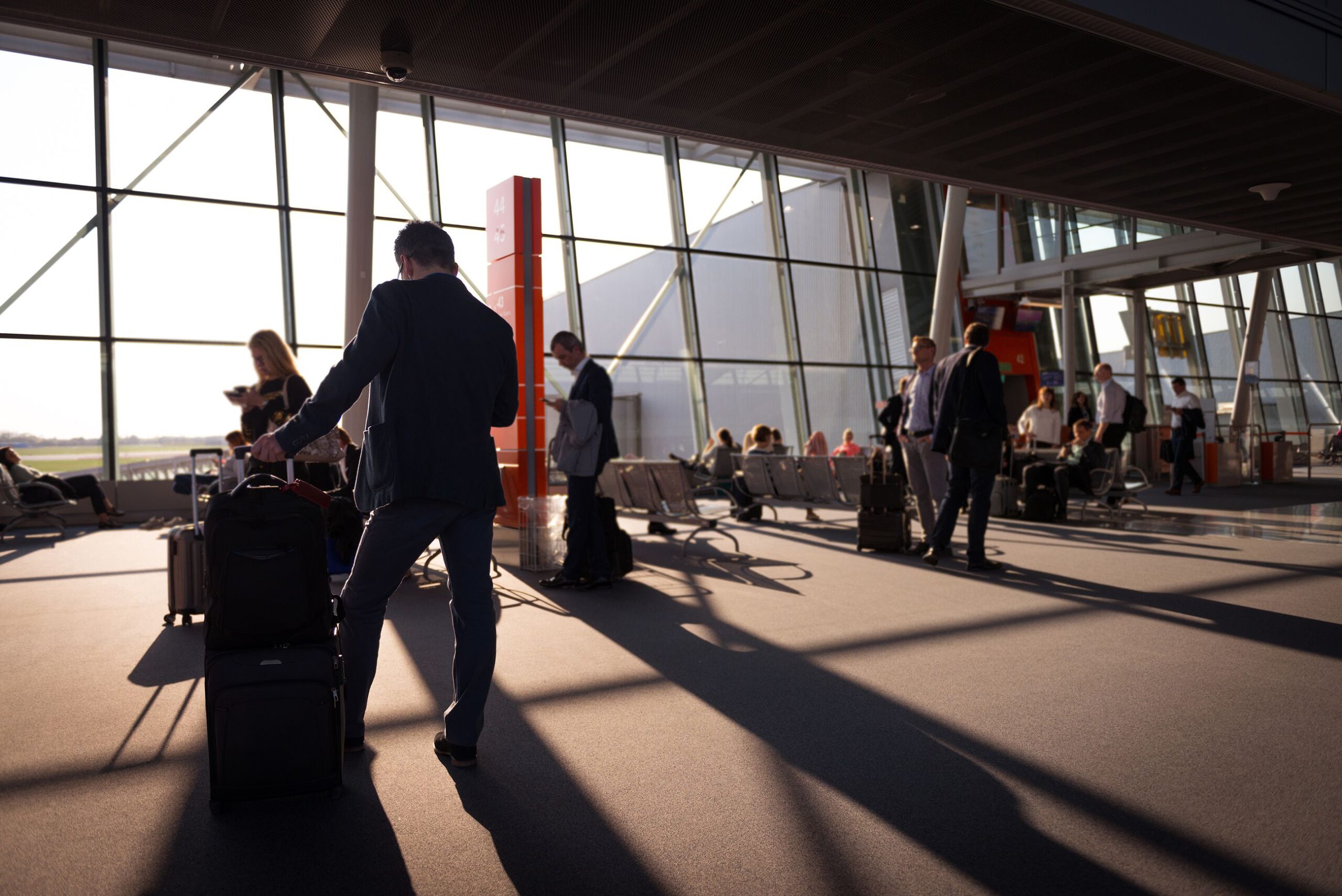 Passengers and luggage moving through a busy international airport terminal