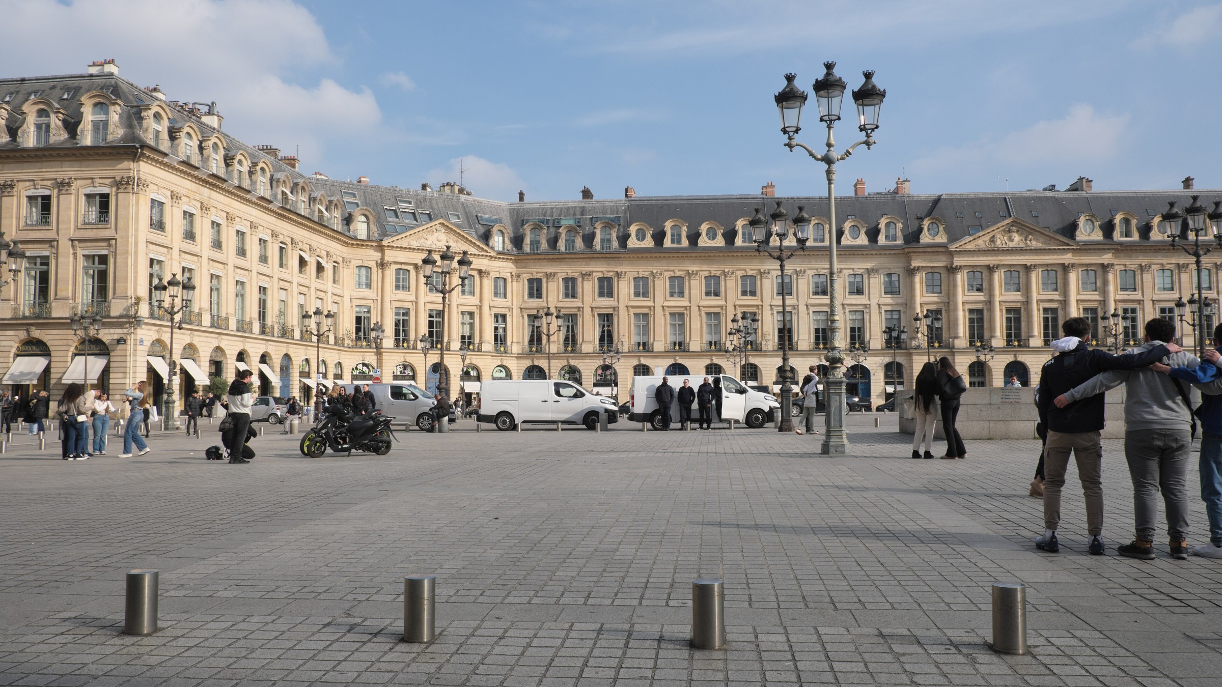 Sunny Place Vendôme with women, pedestrians and cyclists beside Rue Saint-Honoré in Paris