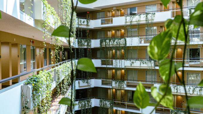 Modern hotel atrium with greenery and a large skylight